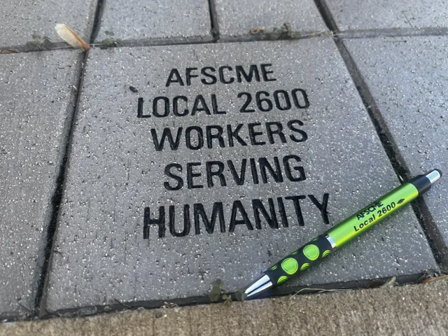 An engraved stone reading AFSCME Local 2600 Workers Serving Humanity