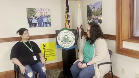 Two people in conversation beside an AFSCME emblem