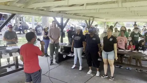 A group gathered beneath a park pavilion