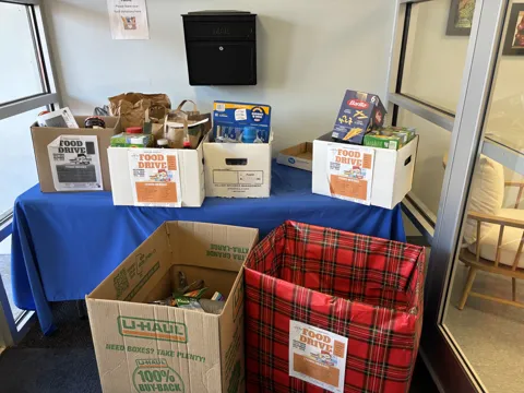 Boxes, bags and food-drive signs arranged at the collection point.