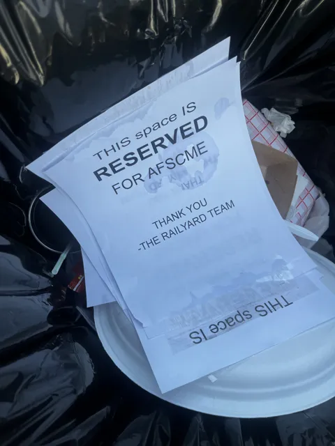 A printed sign says the table is reserved for AFSCME.