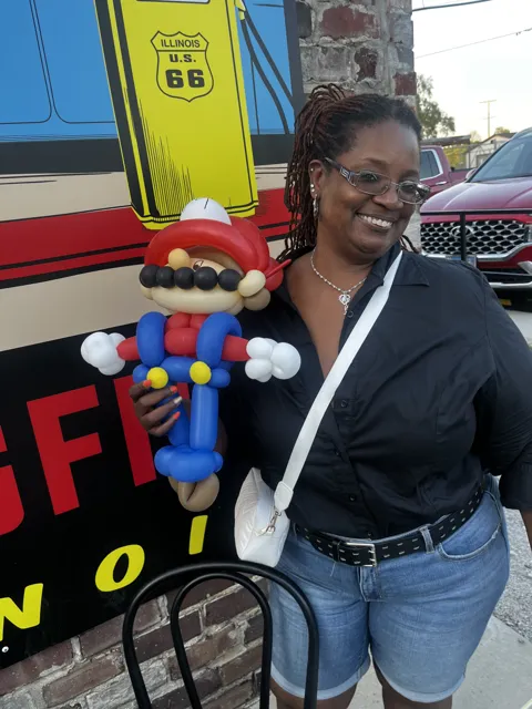 A participant poses with a colorful balloon creation.