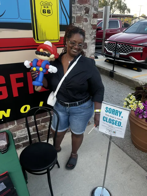 A participant poses with a colorful balloon creation. Alternate view 2.