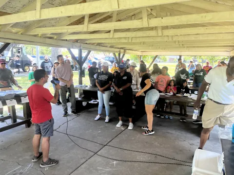 Participants gather under an outdoor picnic shelter. Alternate view 2.