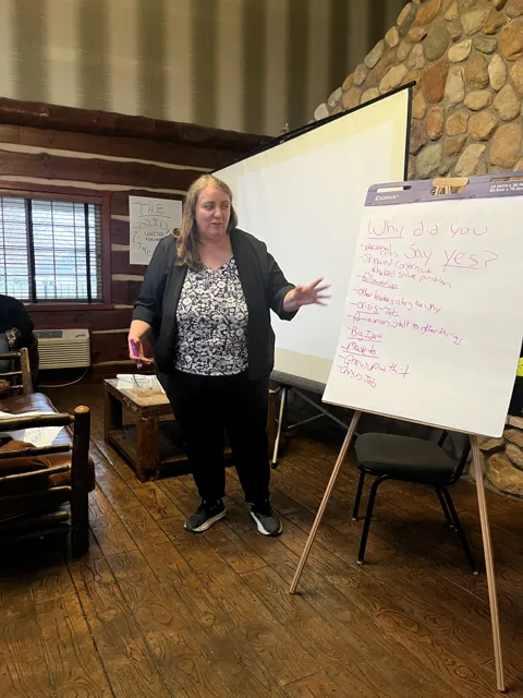 A participant speaks beside a flip chart.