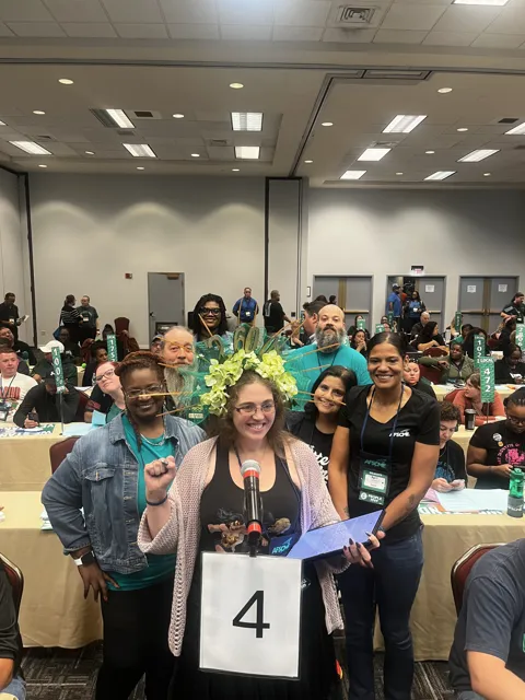 A group poses at a table marked with the number four. Alternate view 2.