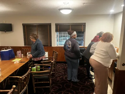 Participants gather around a table.