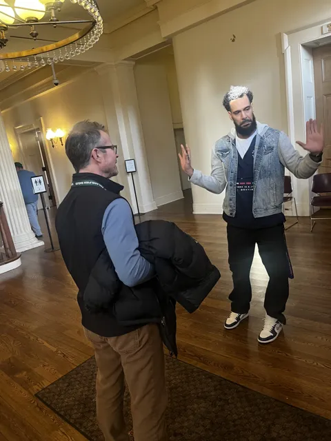 Two people converse in a hallway.