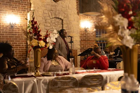 Guests seated at a decorated celebration table.