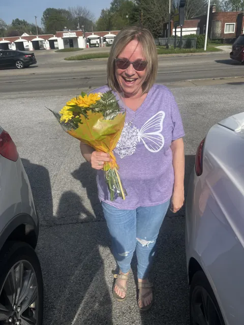 Another photograph of the person holding yellow flowers.