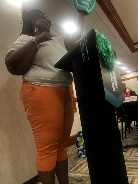 The speaker gestures beside the lectern.