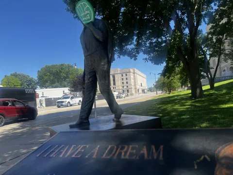 A statue on landscaped grounds with an AFSCME raised-fist symbol nearby. Alternate view 5.