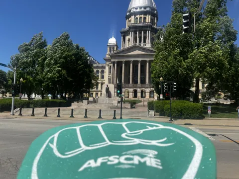 An AFSCME raised-fist symbol in front of the Illinois State Capitol. Alternate view 2.